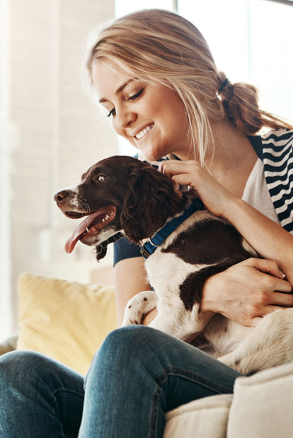 Woman holding a dog on a couch