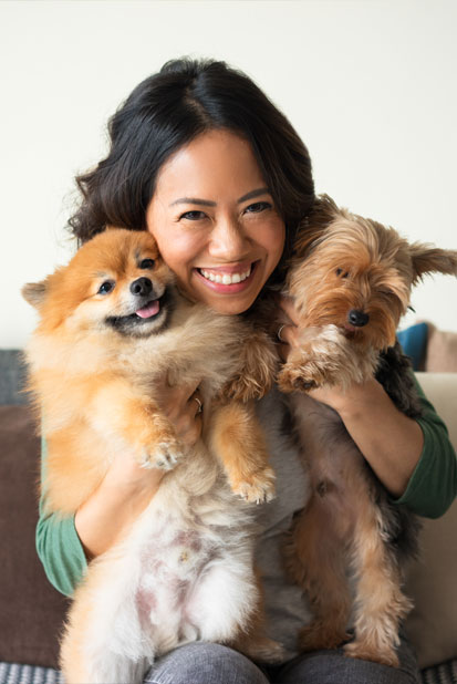 Woman hugging two small dogs